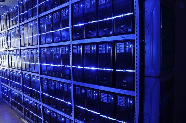 Interior of a data centre showing rows of server racks and cooling systems used to power artificial intelligence and cloud computing