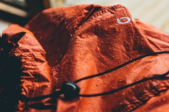 Waterproof outdoor jacket made using PFAS-based coating for water and stain resistance