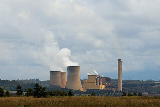 Coal-fired power plant emitting thick smoke and carbon emissions into the atmosphere contributing to climate change