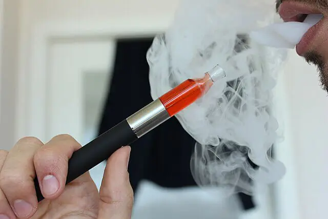 Person vaping with an e-cigarette during the UK vape waste crisis