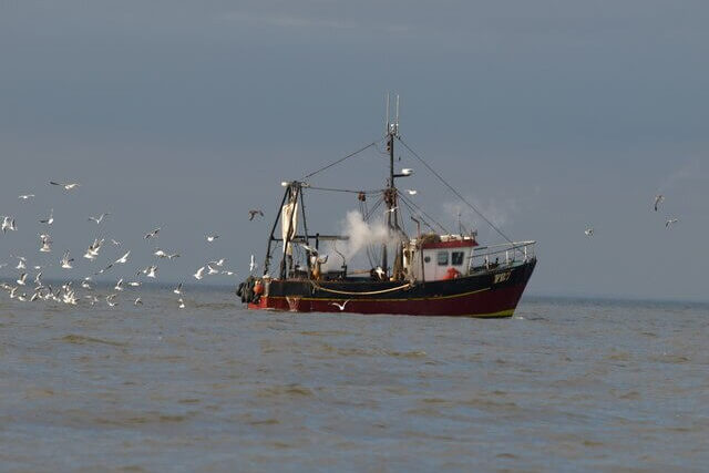 Industrial fishing trawler deploying large nets in UK waters, highlighting impact on marine protected areas