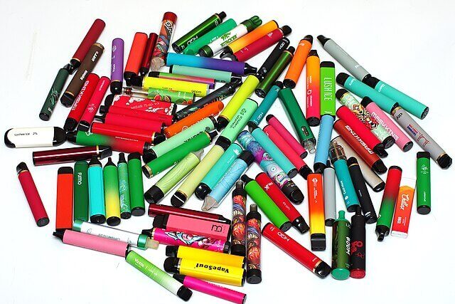 Pile of colourful disposable vapes showing the scale of UK vape waste