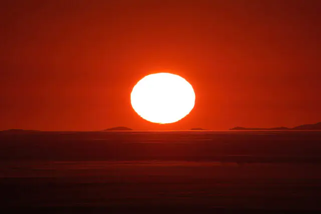 Bright sun rising over a horizon, symbolising extreme heat and intense solar radiation during a heatwave.