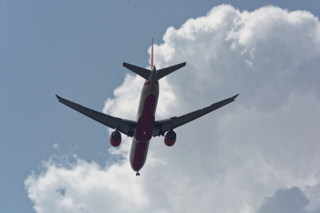 Commercial aeroplane flying through the sky highlighting aviation emissions and climate impacts