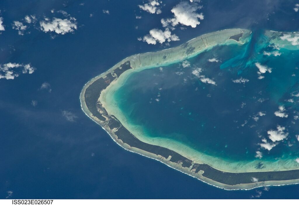 Aerial view of Abemama in Kiribati showing tropical islands, turquoise lagoons, white sandy shorelines and surrounding Pacific Ocean waters.