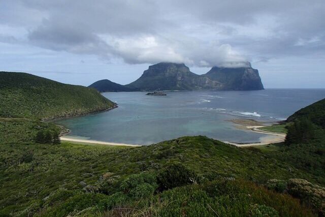 Panoramic view of Lord Howe Island's volcanic peaks, subtropical forests and coastline, showcasing the UNESCO World Heritage island's unique biodiversity and natural landscapes.