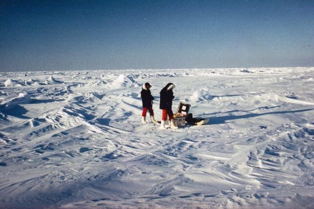 Researchers measuring ice thickness and meltwater on Arctic sea ice during a field study on climate intervention