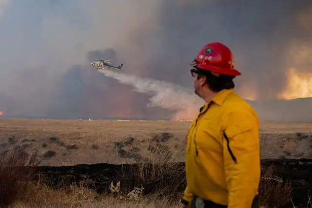 Firefighters battling a large California wildfire amid extreme heat and dry conditions.