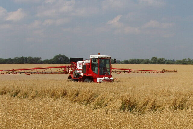 Tractor spraying glyphosate herbicide across an agricultural field